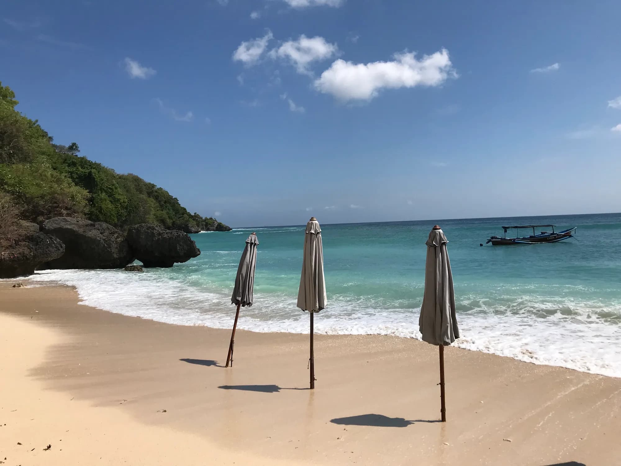 Padang Padang cove, sand, cliffs and a boat, Pecatu, Bali